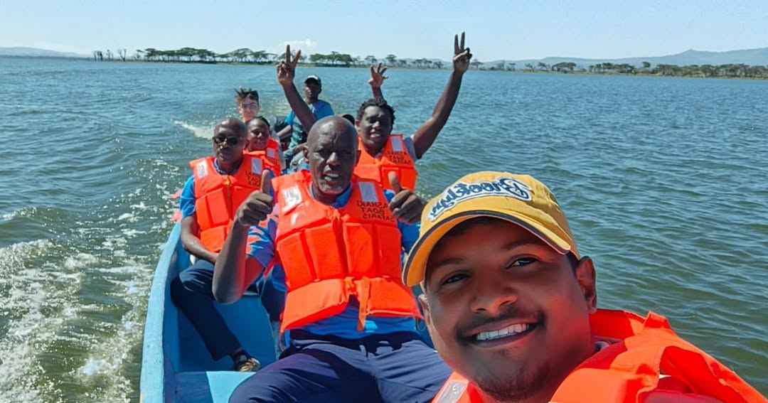 Tourists wearing life jackets enjoying boat ride on lake