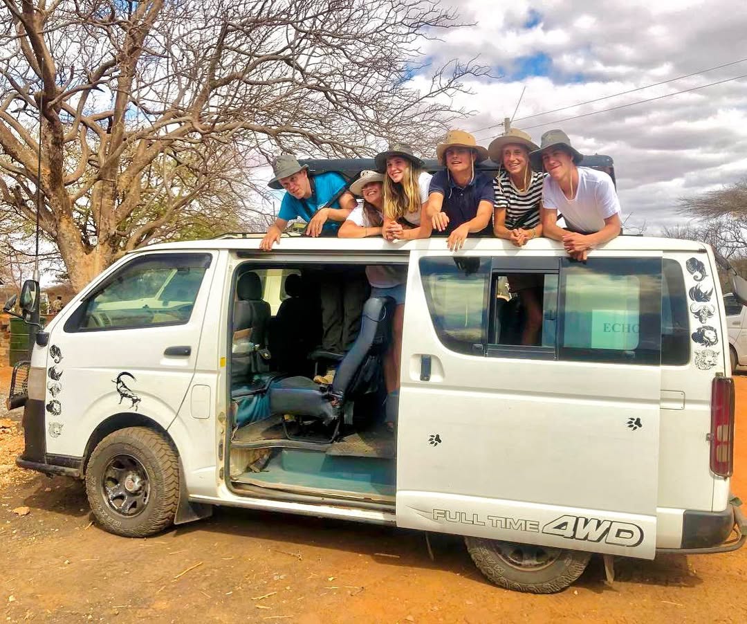 Group of guests leaning out of safari van during outdoor adventure